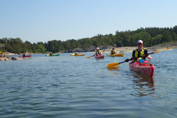 A row of eight paddlers on the Archipelago Sea on a summer's day
